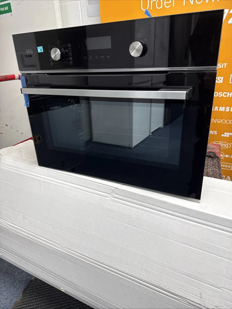 AEG 6000 Series GK6NK401B Combi Quick Compact Built-in Combination Microwave Oven in Black from HomeWise Appliances. Shop photo close up of front of the oven.